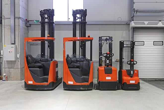 forklifts in a factory moving large barrels